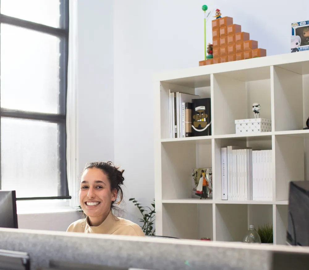 A smiling team member at the bright, welcoming Alpine Spine front desk